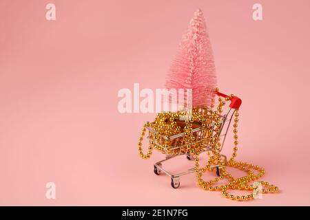 Shopping Mini Trolley mit rosa Winterbaum und Gold Perlen. Vorbereitung auf das neue Jahr Stockfoto
