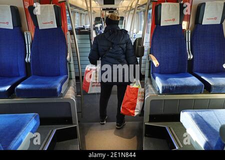 LINKÖPING, SCHWEDEN- 21. DEZEMBER 2020: Frau mit Gesichtsmaske auf einem Pendlerzug während der Corona-Pandemie. Stockfoto