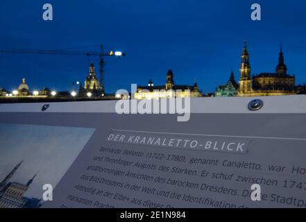 08. Januar 2021, Sachsen, Dresden: Die Informationstafel am Aussichtspunkt des weltberühmten sogenannten Canaletto Blick auf die Elbufer vor der historischen Altstadt-Kulisse mit der Kuppel der Akademie der Künste (l-r), der Frauenkirche, dem Rathaus, dem Ständehaus, dem Georgentor, Die Hofkirche und der Hausmannsturm sind mit dem Kranaletto-Blick überklebt. Dies bezieht sich auf den Baukran, der aufgrund der Bauarbeiten an der Augustusbrücke seit Jahren die Sicht auf die Landschaft beeinträchtigt. Foto: Robert Michael/dpa-Zentralbild/dpa Stockfoto