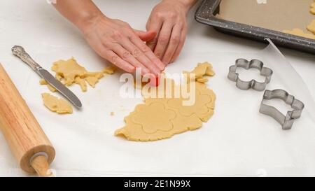 Blume geformte Shortbread-Cookies mit Himbeermarmelade Rezept gefüllt. Frau Hände machen Löcher in Cookie-Mitte Stockfoto