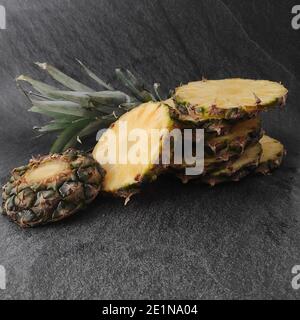 Geschnittene und gehackte Ananas auf dunklem Hintergrund Stockfoto
