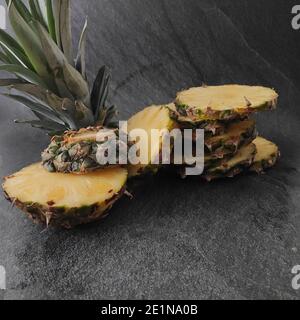 Geschnittene und gehackte Ananas auf dunklem Hintergrund Stockfoto