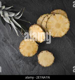 Geschnittene und gehackte Ananas auf dunklem Hintergrund Stockfoto