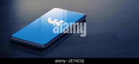 KIEW, UKRAINE-JANUAR, 2021: Vkontakte auf Smartphone-Bildschirm. Ein Smartphone, das auf einer dunklen Oberfläche mit einer Vkontakte-Anwendung liegt. Stockfoto