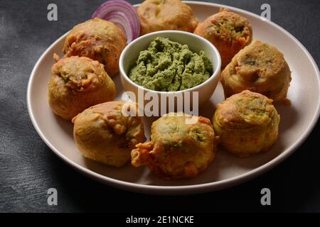 Batata vada beliebtes Straßenessen Indiens, serviert mit grünem Chutney. Stockfoto