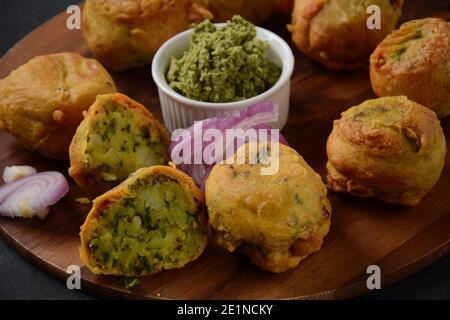 Batata vada beliebtes Straßenessen Indiens, serviert mit grünem Chutney. Stockfoto