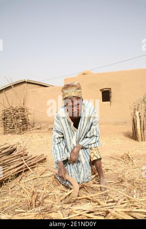 Ein blinder Mann in traditioneller Kleidung arbeitet auf seinem Land im Norden Ghanas, Westafrika Stockfoto