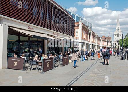 Belebte Straßenszene mit Leuten, die außerhalb der Patisserie sitzen und essen Valerie in Fußgängerzone Brushfield Street mit Christ Church in der Ferne Spitalfi Stockfoto