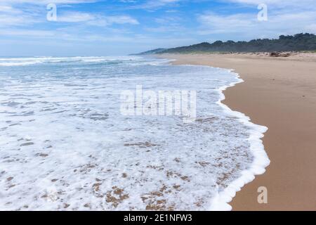 Landschaftlich leerer Strand Meer Wellen Schaum Wasser waschen Wandern Perspektive Nahaufnahme entlang der Küstenlandschaft am Sandstrand Stockfoto
