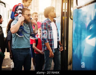 Eine Gruppe von Leuten wartet in der Schlange, um in einen Bus zu gelangen. Stockfoto