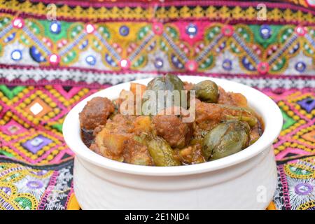 Undhyu oder Oondhyu ein gujarati Delikatessengericht serviert in handi Schüssel mit Hintergrund von gujarati kutchi bharatkam handgefertigten Stickdesign. Mehrfarbige tr Stockfoto