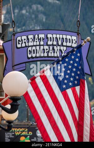 Suspendierte US-Flagge und Straßenschild für die Great Divide Company in Silverton, Colorado, USA Stockfoto