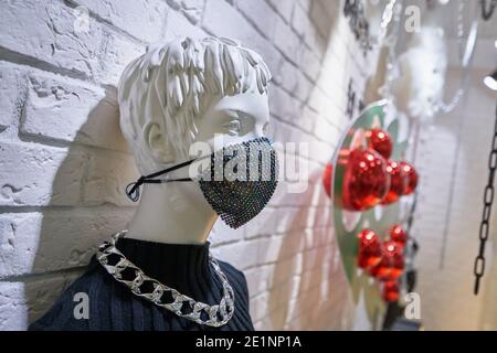 Schaufensterpuppe in einer Schutzmaske auf der Vitrine. Virenschutz- und Präventionskonzept Stockfoto