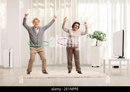 Ältere Paar spinnende Hula Hoop Reifen zu Hause Stockfoto