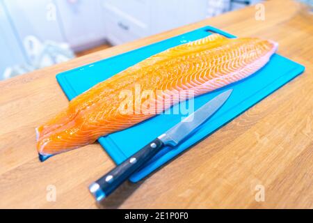 Frischer Lachs und Messer auf Schneidebrett. Draufsicht. Stockfoto