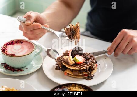 Gabel voller Pfannkuchen mit Händen Stockfoto