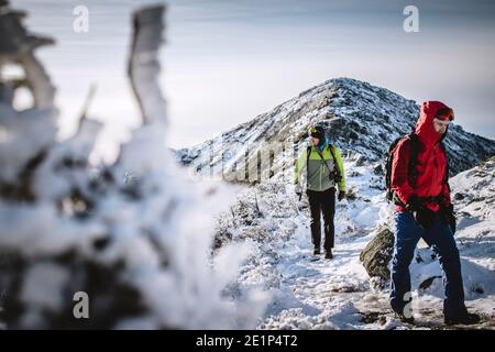 Zwei Winterwanderer auf verschneiten gefrorenen Weg in den Bergen von New Hampshire Stockfoto