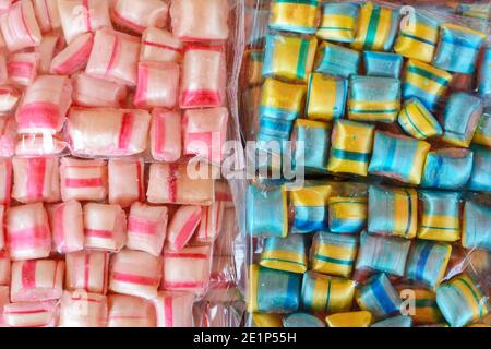 Bunte Bonbons in einer transparenten Plastikfolie als Hintergrund. Stockfoto