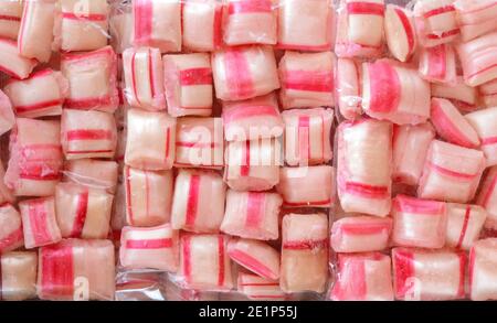 Bunte Bonbons in einer transparenten Plastikfolie als Hintergrund. Stockfoto