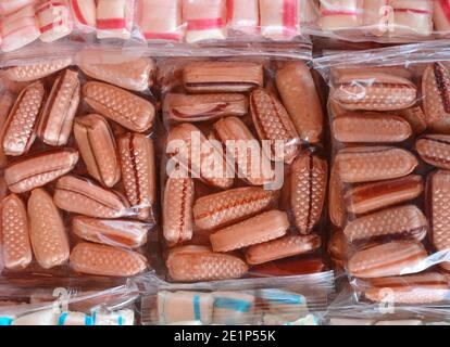 Bunte Bonbons in einer transparenten Plastikfolie als Hintergrund. Stockfoto