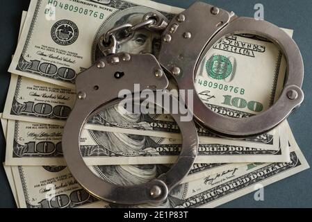 Ukraine. Januar 2021. In diesem Foto Illustrationen Handschellen und hundert US-Dollar Banknoten gesehen angezeigt. Kredit: SOPA Images Limited/Alamy Live Nachrichten Stockfoto