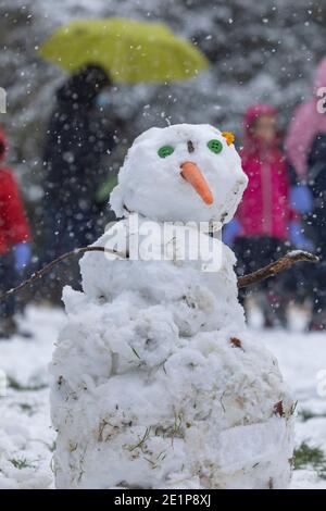 Madrid, Spanien - 08. Januar 2021: Kinder, die mit Schnee spielen und Schneemänner machen, im Buen Retiro Park in Madrid, mitten in einem verschneiten Tag, fällig Stockfoto