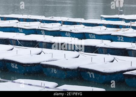 Madrid, Spanien - 08. Januar 2021: Boote mit Schnee bedeckt und vertäut in der Estanque Grande del Retiro, Madrid, in der Mitte eines verschneiten Tages, aufgrund einer Stockfoto