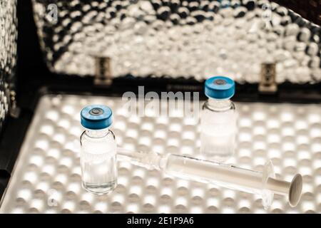 Nahaufnahme der Spritze mit Nadel und Impfstoffinjektion Kühlschrank beleuchtet - covid-19 Impfkonzept Gesundheit und Medizin Stockfoto