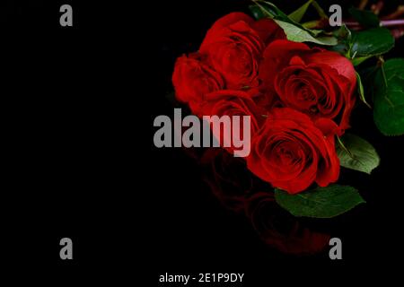 Valentinstag Hintergrund mit Bouquet von schönen roten Rosen auf schwarzer Oberfläche. Muttertag oder Valentinstag. Stockfoto