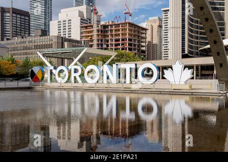 Toronto, Kanada - 29. September 2020: Das neue Toronto-Schild auf dem Nathan Phillips Square wird am 29. September 2020 mit dem Toronto City Hall im Hintergrund gesehen. Stockfoto