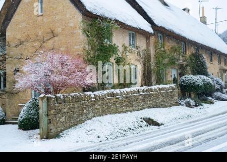 Cotswold Stein Reethäuser im Schnee zu Weihnachten. Taynton, Cotswolds, Oxfordshire, England Stockfoto