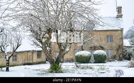 Cotswold Steinhütte und Scheune im Dezember Schnee. Taynton, Cotswolds, Oxfordshire, England Stockfoto