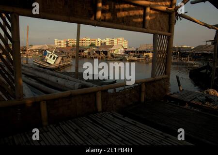 Fischerboote auf dem Gezeitengebiet, Fischerdorf und neu errichtetes flaches Gebäude von innen gesehen ein verlassenes Seegüterrestaurant in Marunda Dorf im Küstengebiet von Jakarta, Indonesien. Archivfoto (2008). Stockfoto