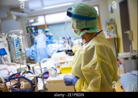 Ludwigsburg, Deutschland. Januar 2021. Eine Intensivkrankenschwester steht im Raum eines Covid 19-Patienten auf einer Intensivstation des RKH Klinikum Ludwigsburg. In Baden-Württemberg wird die Belegung von Intensivstationen über ein Cluster-Konzept gesteuert. Intensivpatienten können zwischen den Spitälern der sechs Servicebereiche verlegt werden, um eine bessere Verteilung zwischen den Spitälern zu erreichen. Quelle: Sebastian Gollnow/dpa/Alamy Live News Stockfoto