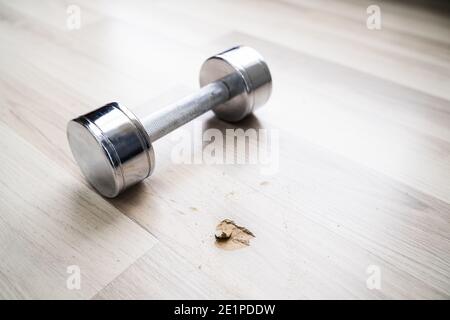 Loch In Laminatboden Von Gefallener Hantel Stockfoto