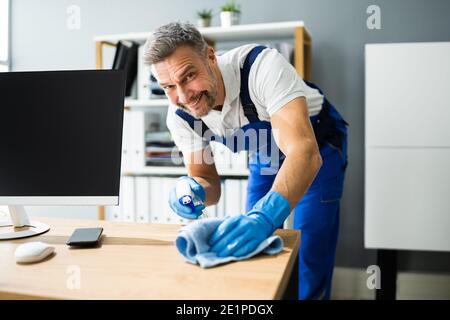 Professionelle Arbeitsplatz Hausmeister Service. Reinigung Des Büroschreibtischs Stockfoto