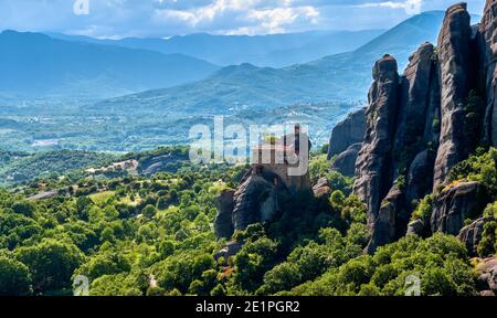 Blick auf das Kloster St. Nicholaos Anapafsas auf der Spitze der sedimentären Säule und grünen Hügeln des Meteora-Tals am Mittag. Griechenland, UNESCO-Weltkulturerbe Stockfoto