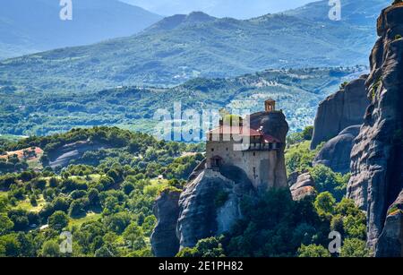 Nahansicht des Klosters St. Nicholaos Anapafsas auf der Spitze der sedimentären Säule, grüne Hügel des Meteora-Tals am Mittag. Griechenland, UNESCO-Weltkulturerbe Stockfoto