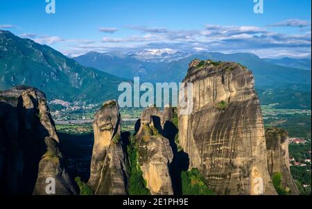 Morgenansicht der Meteora Felsen und Säulen im Vordergrund, Tal und Berge im Hintergrund. Schöne Wolken, Dorf. Griechenland, UNESCO-Weltkulturerbe Stockfoto