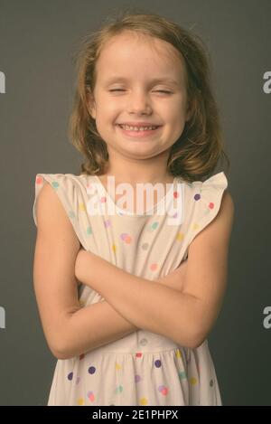 Nette junge Mädchen mit blondem Haar gegen grauer Hintergrund Stockfoto