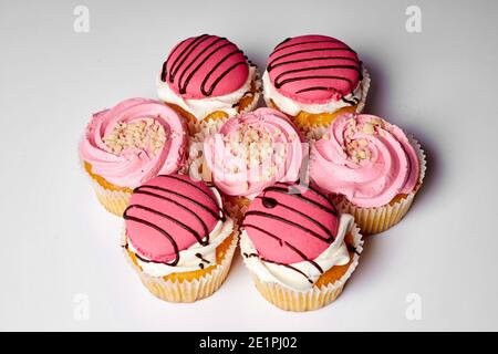 Kuchen Dessert, leckere Muffins mit rosa Sahne. Süßes Vergnügen. Set von Kuchen auf weißem Hintergrund Stockfoto