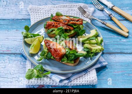 Sardinen in Tomatensauce mit Avocado und Lammsalat Toast – High-Angle-Ansicht Stockfoto