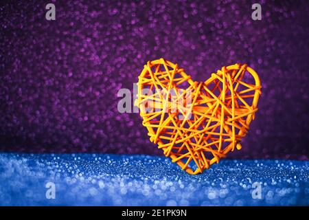 Konzeptuelles Herz auf einem glitzernden Hintergrund von unbeleuchteten Lichtern im Hintergrund des Valentinstag. Stockfoto