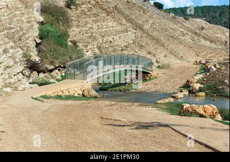 Fußgängerbrücke über den Fluss auf dem Hintergrund eines Steinberg in Israel Stockfoto