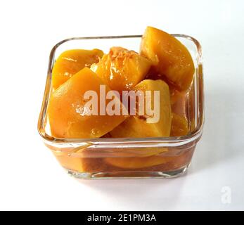 Pfirsichkompott aus der Dose in einer Glasschale, isoliert auf Weiß Hintergrund Stockfoto