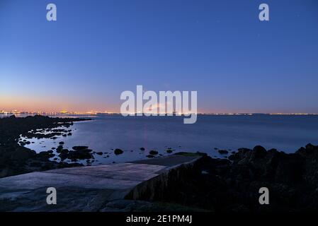 Sonnenuntergang am Seapoint Beach. Weitwinkelansicht von Dublin Waste to Energy (Covanta Plant), Poolbeg CCGT und Pigeon House Power Station am Abend Stockfoto