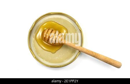 Honig und hölzerne Dipper in einem Glasdeckel isoliert auf weißem Hintergrund. Stockfoto