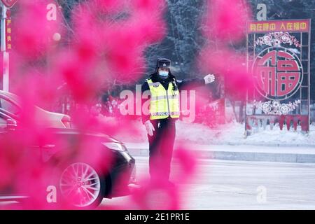 Dahinggan, Chinas Provinz Heilongjiang. Januar 2021. Verkehrspolizist Sun Chen leitet den Verkehr an einer Kreuzung im Bezirk Huzhong in Dahinggan, nordöstlich der Provinz Heilongjiang, 8. Januar 2021. Sun Chen ist seit 35 Jahren Verkehrspolizist. Im Bezirk Huzhong, genannt "die kälteste Stadt Chinas", klebte Sun an seinem Posten, um die Verkehrsordnung aufrechtzuerhalten. Trotz des extrem kalten Wetters mit der niedrigsten Temperatur von etwa minus 40 Grad Celsius nahm er früh am Morgen seine Schicht auf. Quelle: Wang Jianwei/Xinhua/Alamy Live News Stockfoto