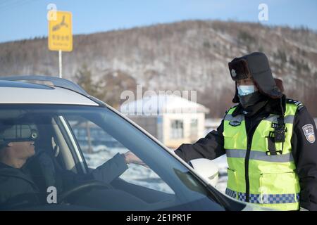 Dahinggan, Chinas Provinz Heilongjiang. Januar 2021. Verkehrspolizist Sun Chen überprüft auf einer Straße im Bezirk Huzhong in Dahinggan, nordöstlich der Provinz Heilongjiang, einen Führerschein, 8. Januar 2021. Sun Chen ist seit 35 Jahren Verkehrspolizist. Im Bezirk Huzhong, genannt "die kälteste Stadt Chinas", klebte Sun an seinem Posten, um die Verkehrsordnung aufrechtzuerhalten. Trotz des extrem kalten Wetters mit der niedrigsten Temperatur von etwa minus 40 Grad Celsius nahm er früh am Morgen seine Schicht auf. Quelle: Wang Jianwei/Xinhua/Alamy Live News Stockfoto