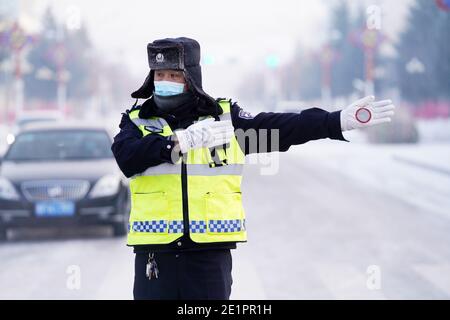 Dahinggan, Chinas Provinz Heilongjiang. Januar 2021. Verkehrspolizist Sun Chen leitet den Verkehr an einer Kreuzung im Bezirk Huzhong in Dahinggan, nordöstlich der Provinz Heilongjiang, 8. Januar 2021. Sun Chen ist seit 35 Jahren Verkehrspolizist. Im Bezirk Huzhong, genannt "die kälteste Stadt Chinas", klebte Sun an seinem Posten, um die Verkehrsordnung aufrechtzuerhalten. Trotz des extrem kalten Wetters mit der niedrigsten Temperatur von etwa minus 40 Grad Celsius nahm er früh am Morgen seine Schicht auf. Quelle: Wang Jianwei/Xinhua/Alamy Live News Stockfoto